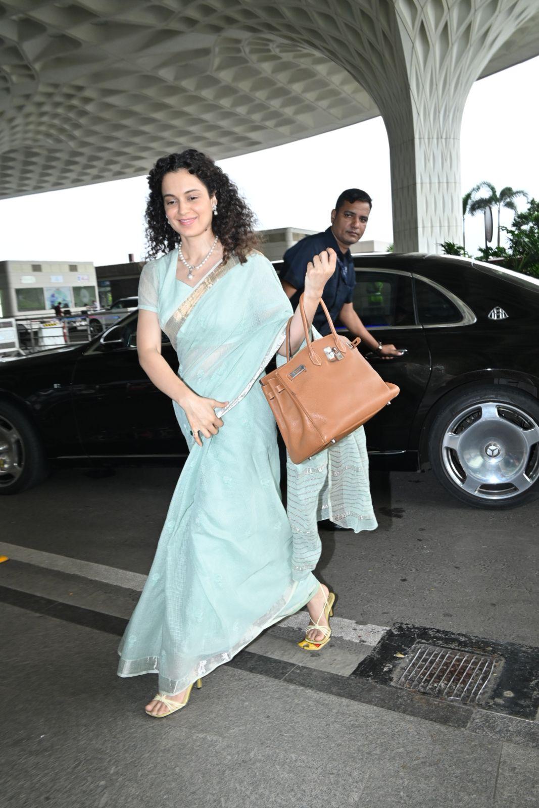 The saree gracefully draped around her, accentuating her poise and style.